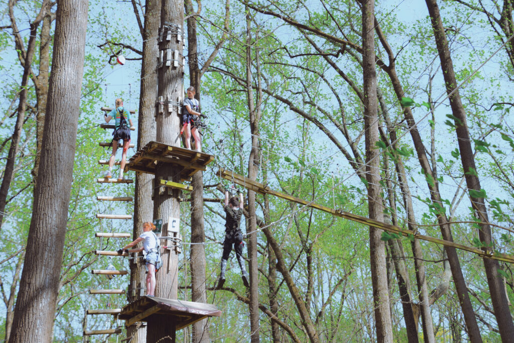 Guests climbing and ziplining through the trees at The Adventure Park at Sandy Spring