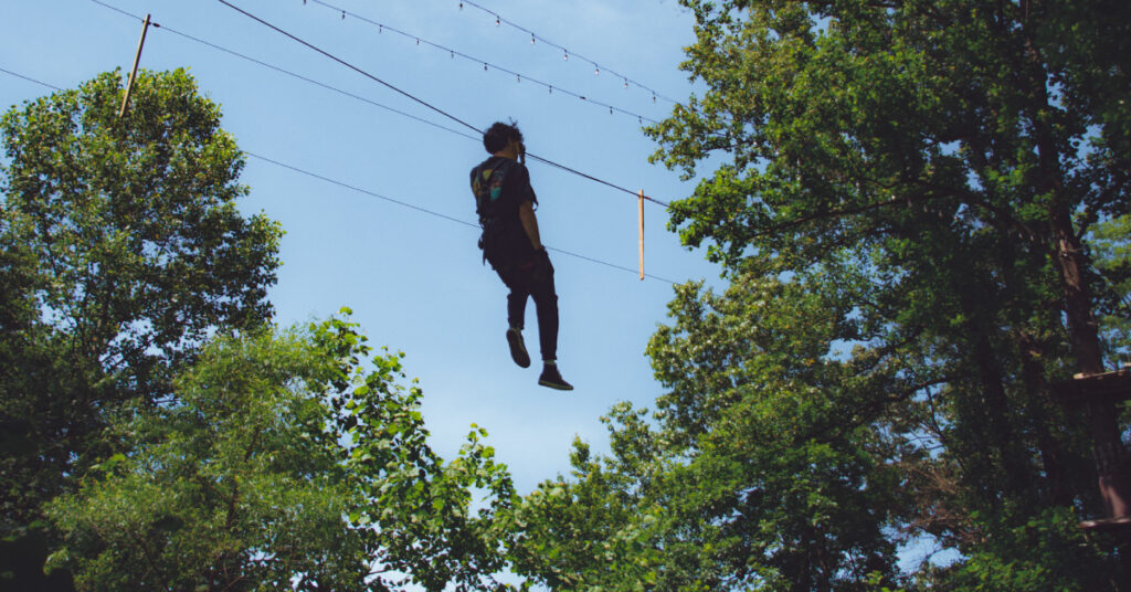Guest ziplining through the forest canopy at The Adventure Park at Sandy Spring, Maryland